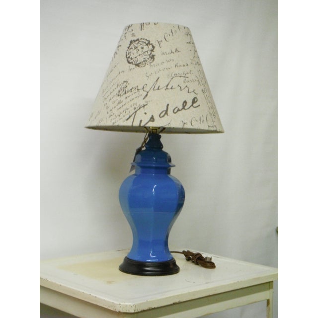 Add some Hollywood chic style to your space with this blue ginger jar regency style table lamp. The lamp has a French...