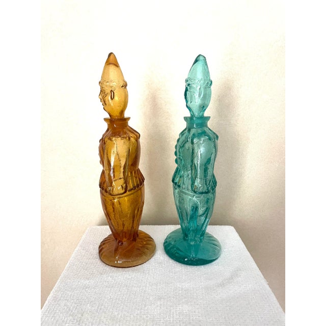 This pair of Bischoff glass decanters are adorable and rare! One is amber and the other aqua. They depict clown figures...