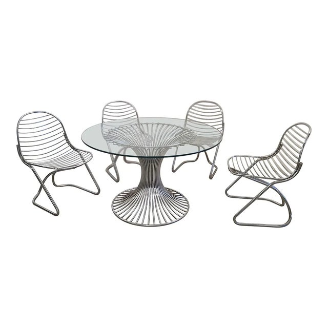 Glass table with steel base complete with four steel chairs. Vintage style. Table dimensions (dxh) 118 x 71 cm Chair...