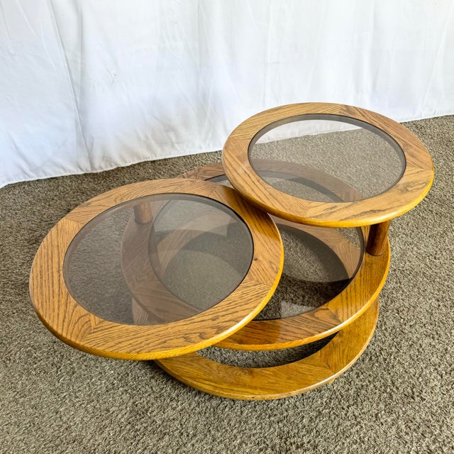 This striking Mid-Century Modern coffee table features a sculptural three-tier swivel design crafted from solid oak with...