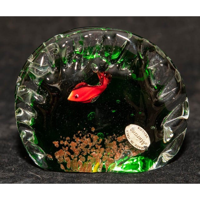 Classic Murano acquario block: a green-tinted body encasing a red fish above decorative gravel and reef elements, with the...