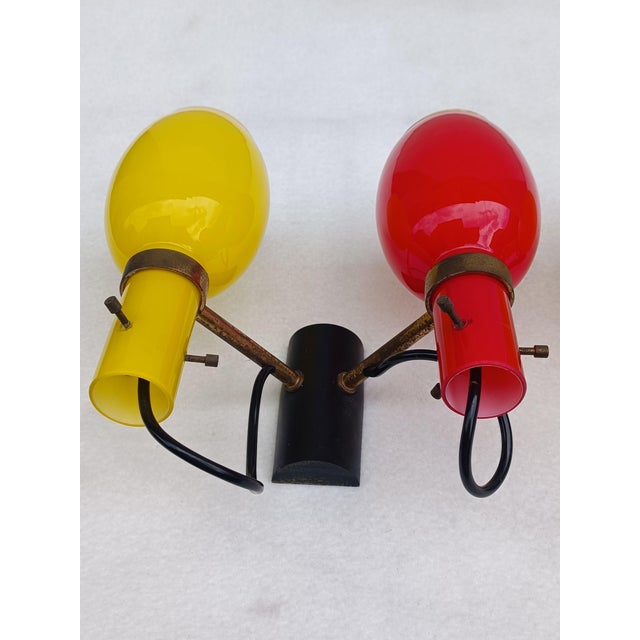 Pair of red and yellow stained glass wall sconces on brass frame with double illumination. Italian manufacture referable...