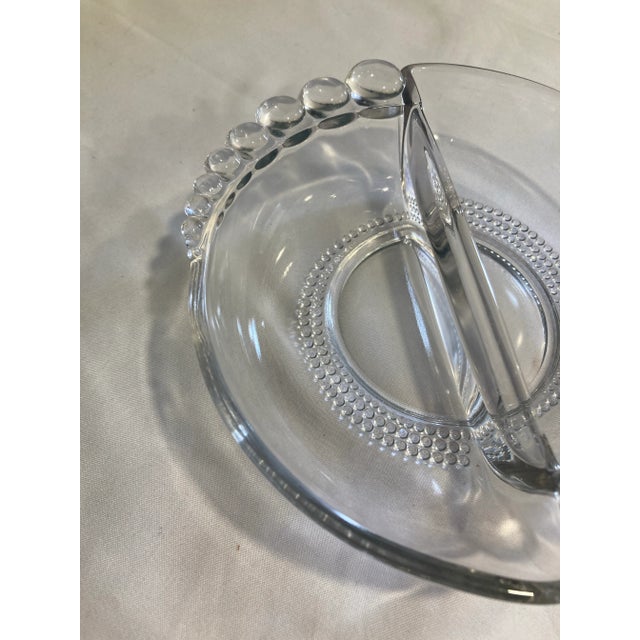 This divided relish dish by Duncan Miller in the signature Candlewick pattern features the classic beaded edge and beaded...