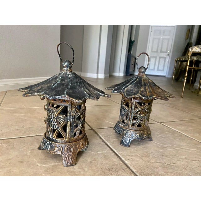 Pair of antique Chinese heavy cast iron pagoda garden lanterns with original patina, having a handle for hanging, hinged...