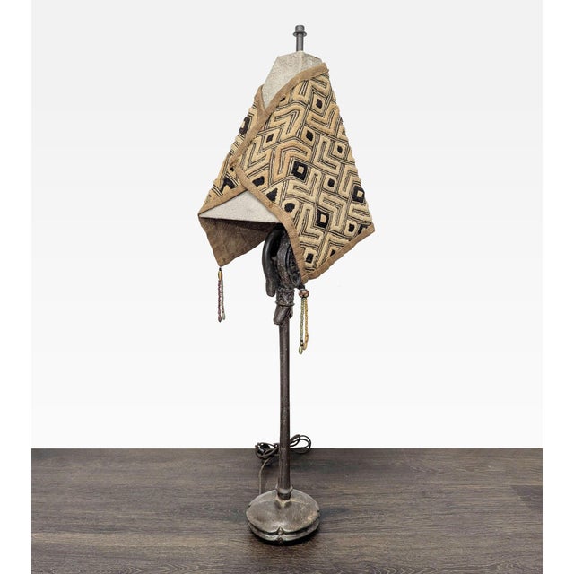 Add a touch of culture to your home with this unique table lamp. It features a sculpted tribal-style base with charming...