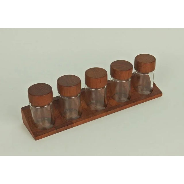 Checkered strip holders with a checkerboard pattern, pierced with five holes where five closed glass spice pots come to...