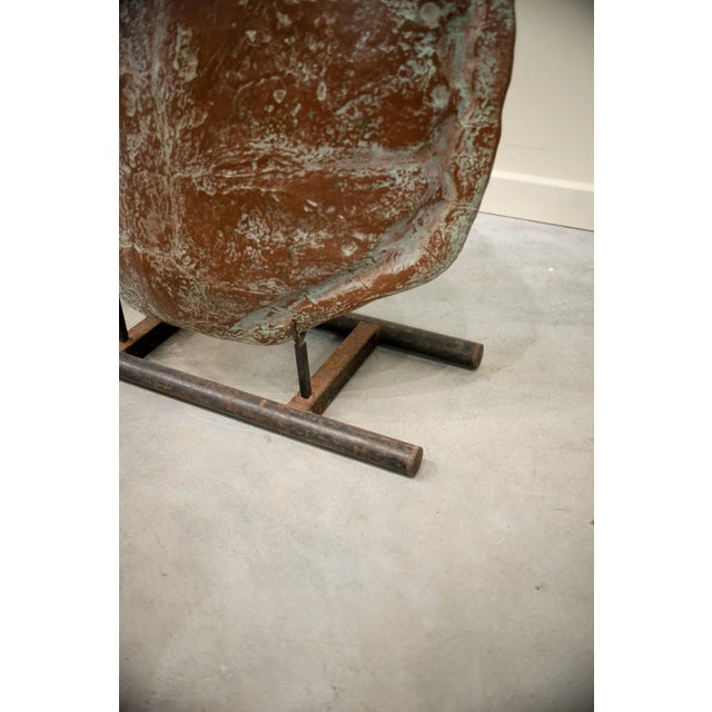 Turtle shell sculpture performed in fiber. Black-painted tubular iron support.