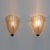 A pair of textured murano glass wall sconces. The fluted and curved glass creates a striking decorative effect, completely...