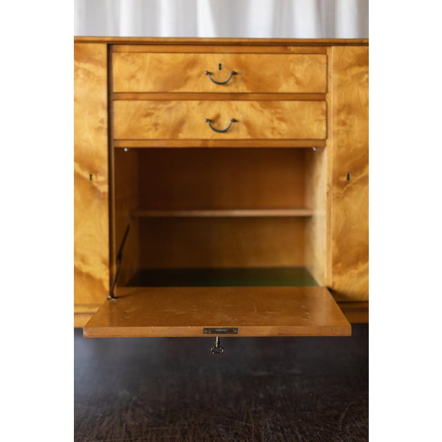 This Mid Century flame birch sideboard showcases striking book-matched flame birch veneer, celebrating the natural...
