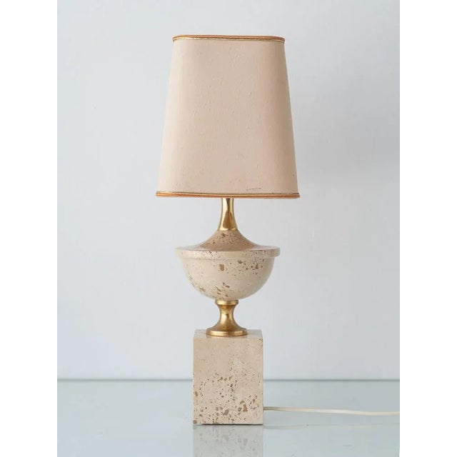 Elegant travertine and brass table lamp attributed to Philippe Barbier, produced in Italy during the 1970s. The design...