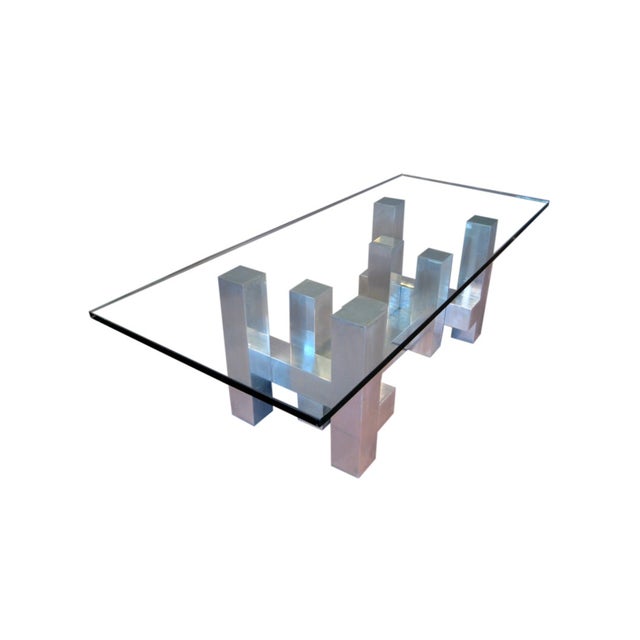 Details: Dimensions: 52” W x 38” D x 17” H Materials: Aluminum base, thick glass top Design: Stacked geometric “cityscape”...