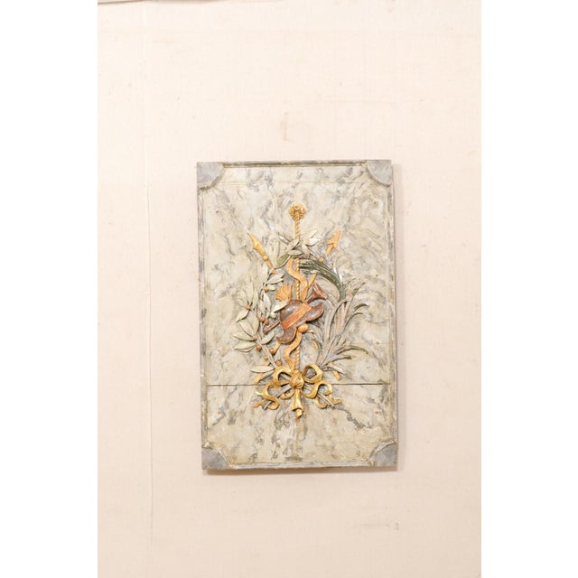 An Italian hand-carved wall plaque, with its original painted and gilt finish, from the 19th century. This antique wall...