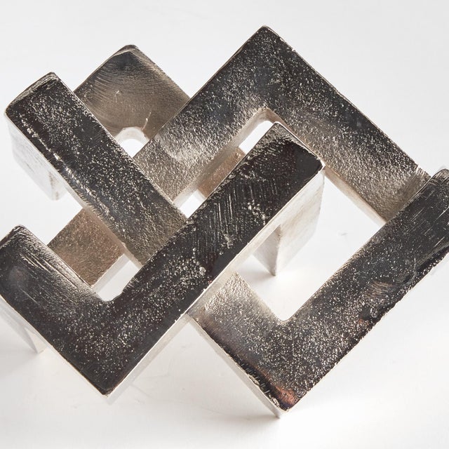 A geometric marvel, this linear sculpture is a strong, substantial accent in a silver finish. Place atop a stack of books...