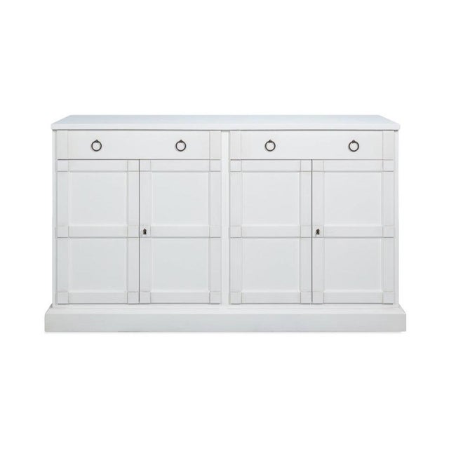 Two long drawers sit above four doors in a solid-pine case painted white from the plinth to the top edge. Ring pulls hang...