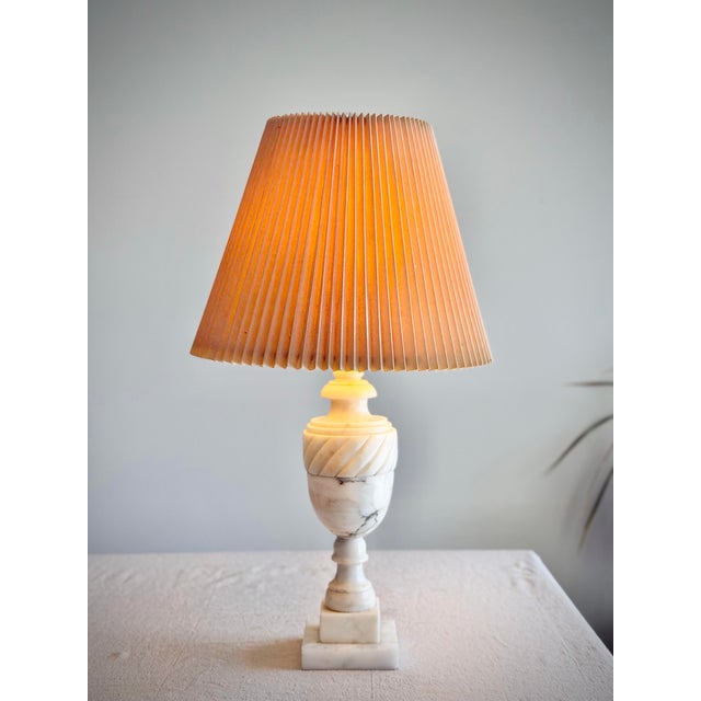 A vintage carved alabaster table lamp featuring a turned baluster form, spiral-fluted collar, and stepped square plinth...