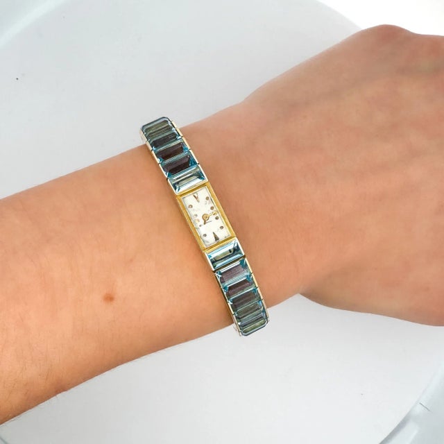 Vintage Blancpain Rayville Swiss made ladies watch in 14K yellow gold featuring a channel set emerald cut aquamarine...