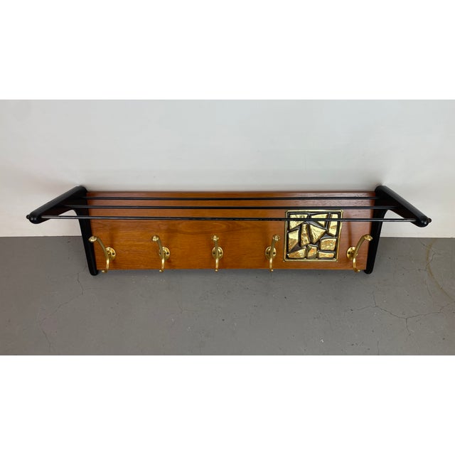 Elegant Mid-Century Modern wall-mounted coat rack designed by Alfred Hendrickx for Belform, featuring a warm wooden back...