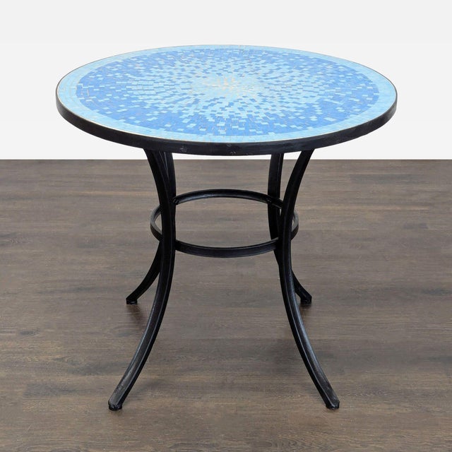 Add a pop of color to your space with this Crate & Barrel round patio table. The vibrant blue mosaic tile top sits on a...
