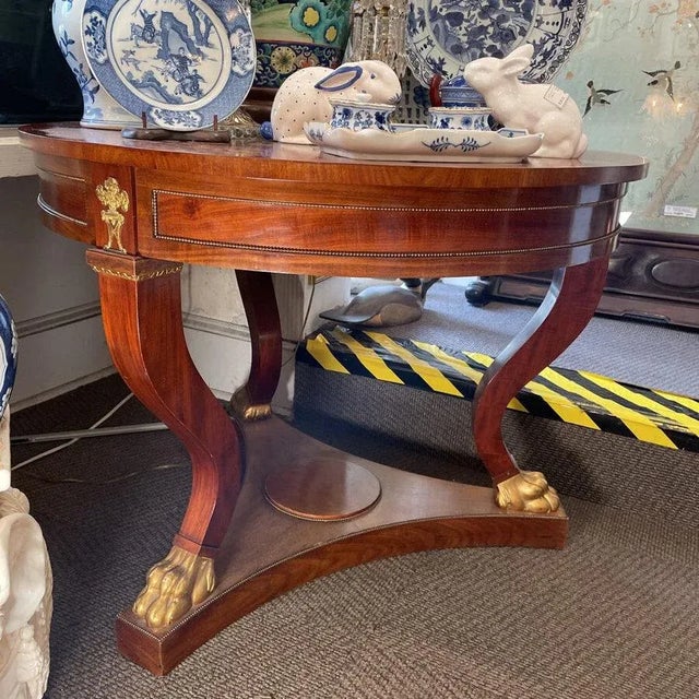 Neoclassical Giltwood and Doré Bronze-Mounted Mahogany Center Table, circa 1850. The circular figured-mahogany top above a...