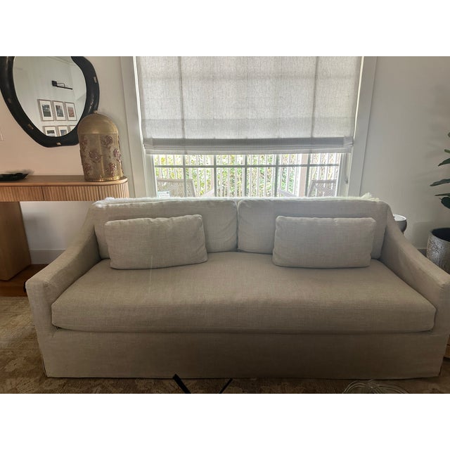 A pair of Restoration Hardware Belgian Slipcovered Slope Arm Bench-Cushion sofas in Sand Performance Linen, in excellent,...