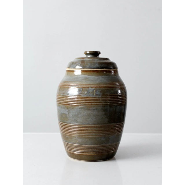 Vintage studio pottery jar showcasing a bold handcrafted form with a striking blue and brown glaze and beautifully tooled...