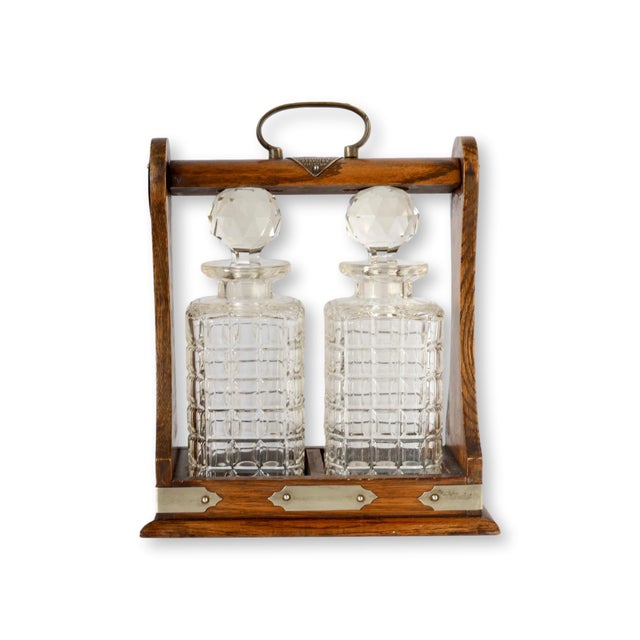Antique English oak and silver plate tantalus with two cut glass decanters and an engraved presentation plaque from a York...