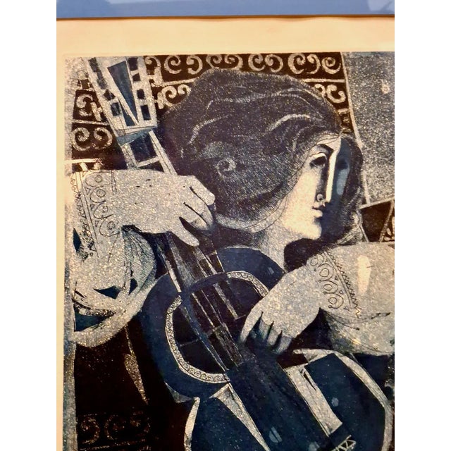 A woman with flowing hair plays her guitar so beautifully that she captivates the full attention of a bird. Entranced, the...