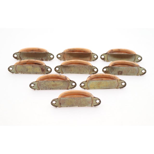 Vintage Art Deco style drawer pulls made of warm tan or peach Bakelite bands and polished brass finish steel. The original...