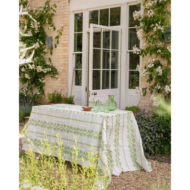A stunning hand-embroidered rectangular tablecloth, featuring a vine motif, on a 100% hand-dyed linen background in three...