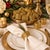 A dramatic set of 14 vintage gold-tone metal napkin rings featuring an airy, sculptural design of intertwined metal...