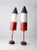 This is a pair of large vintage buoys. The red, white, and blue torpedo shaped buoys feature red metal stands with cement...