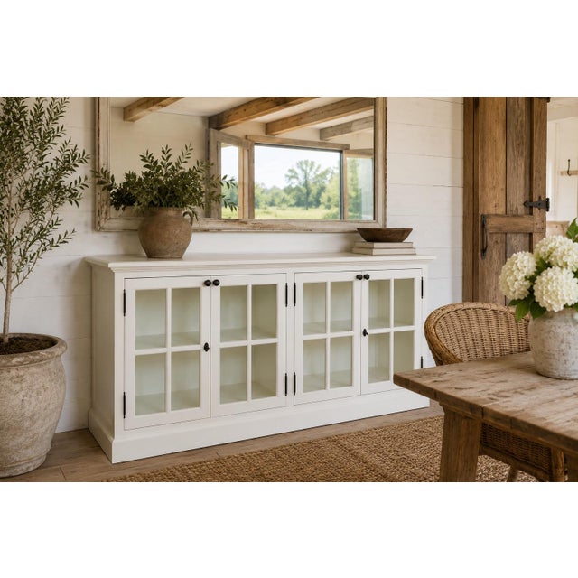 A beautifully scaled 72-inch white painted sideboard featuring four paneled glass doors and a clean, architectural...
