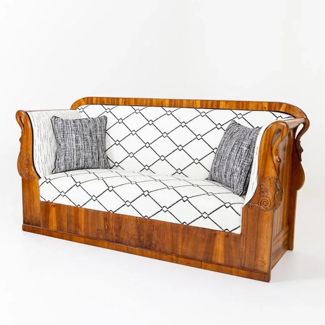 Biedermeier sofa with a straight frame and rounded backrest. The seat is veneered in walnut and decorated on the high...