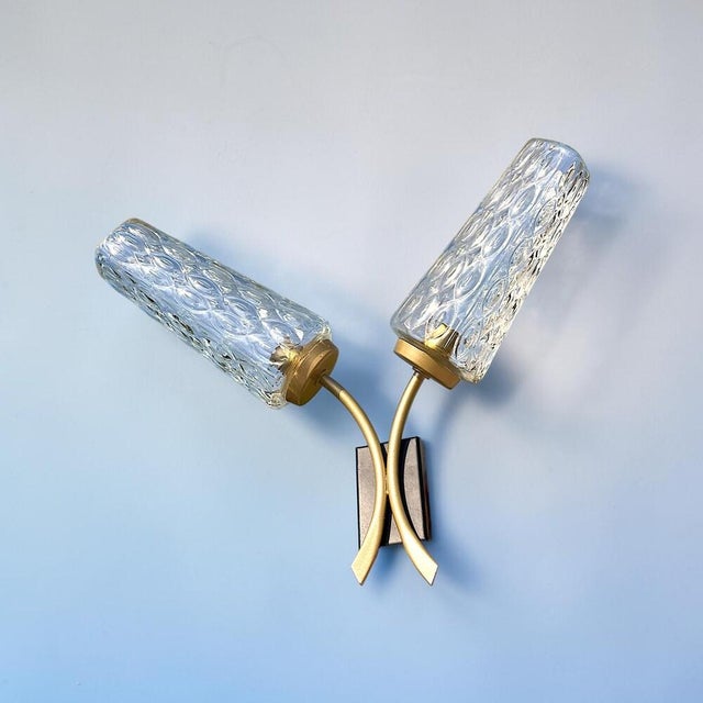 Mid-Century Modern double wall sconce, with sculptural brass arms (spray painted gold), a black rectangular backplate, and...