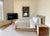 Custom-made Eastern King bed featuring full upholstery in smooth tan leather, including a fully wrapped leather base for a...