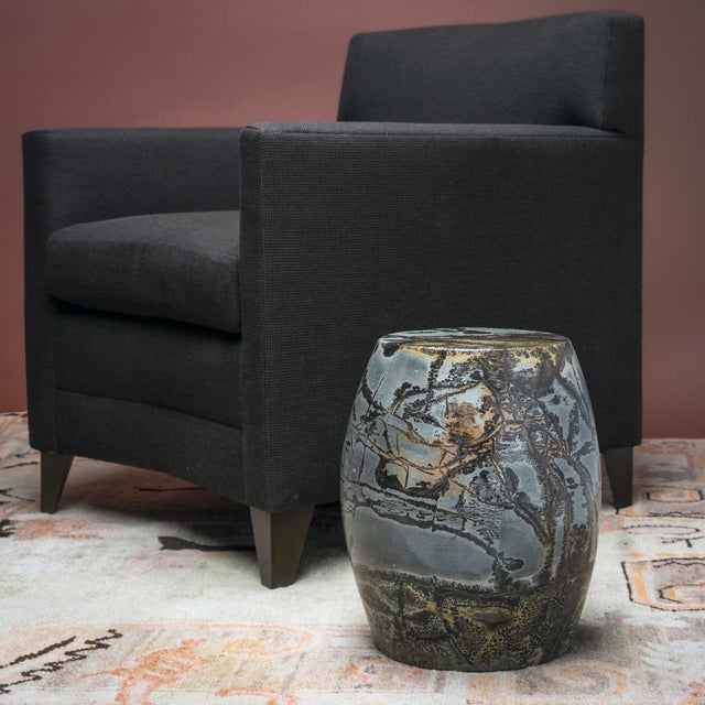 As if blotted with ink and brushed with calligraphy, this polished painting stone drum from Guangxi province is marked...