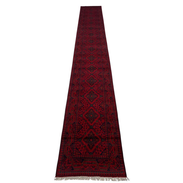 This extra-long runner features a vivid red field with a continuous row of dark navy diamond medallions. Angular floral...