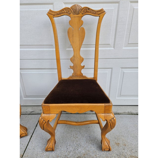 Queen Anne-style wooden dining chairs with ball-and-claw feet and dark brown upholstered seats. This set is in good...
