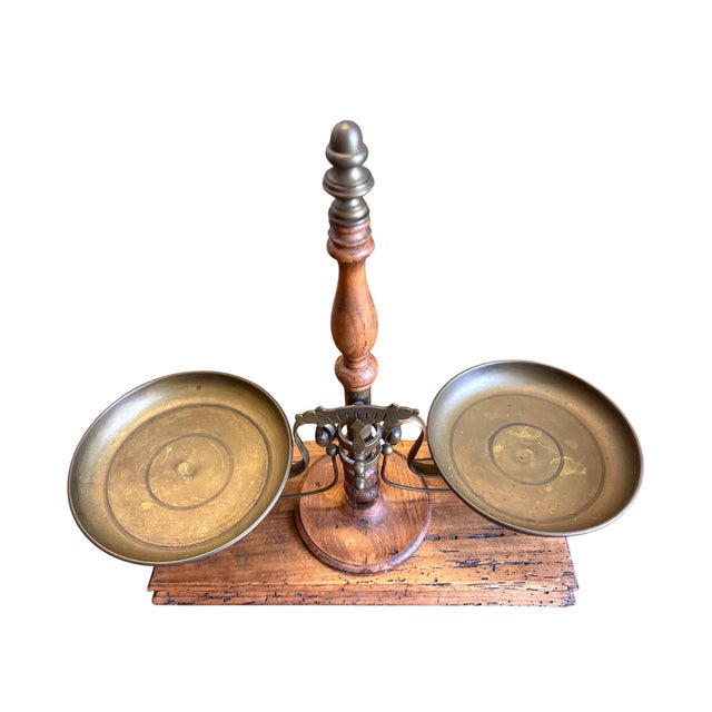 Charming vintage Italian balance scale crafted from brass and wood, featuring twin brass weighing pans and a turned center...