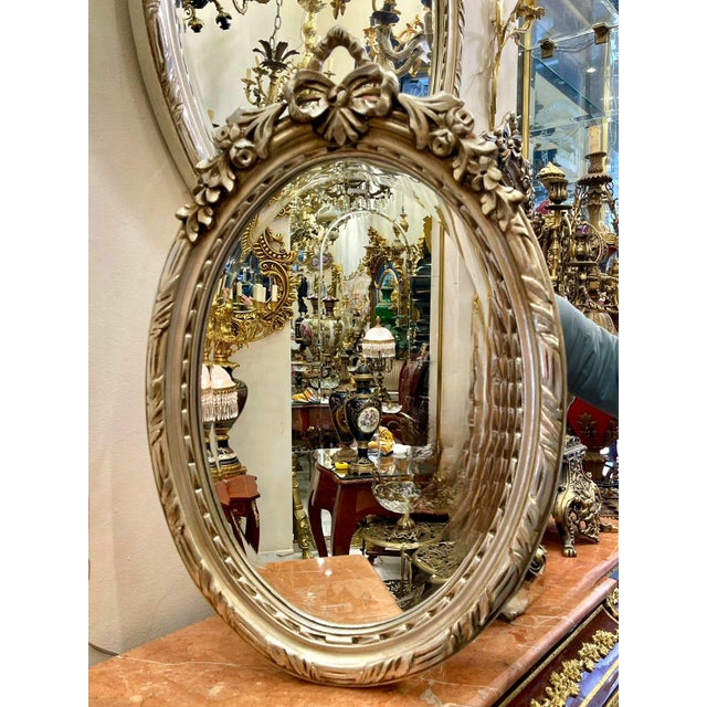 French Oval Wall Mirror – Silver Leaf Frame With Ribbon Crest For Sale - Image 3 of 3