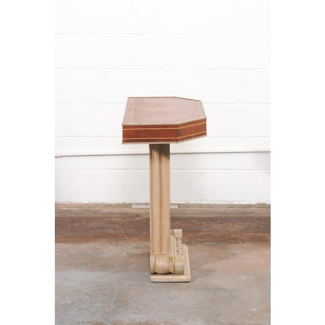 A French wooden pedestal wall console table with leather top from the mid 20th century. This mid-century table from...