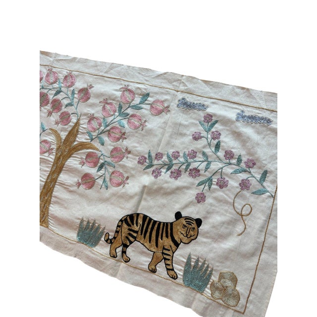 Hand-embroidered Suzani panel from Uzbekistan, worked in fine floss on a cream cotton ground. Three tigers move across the...