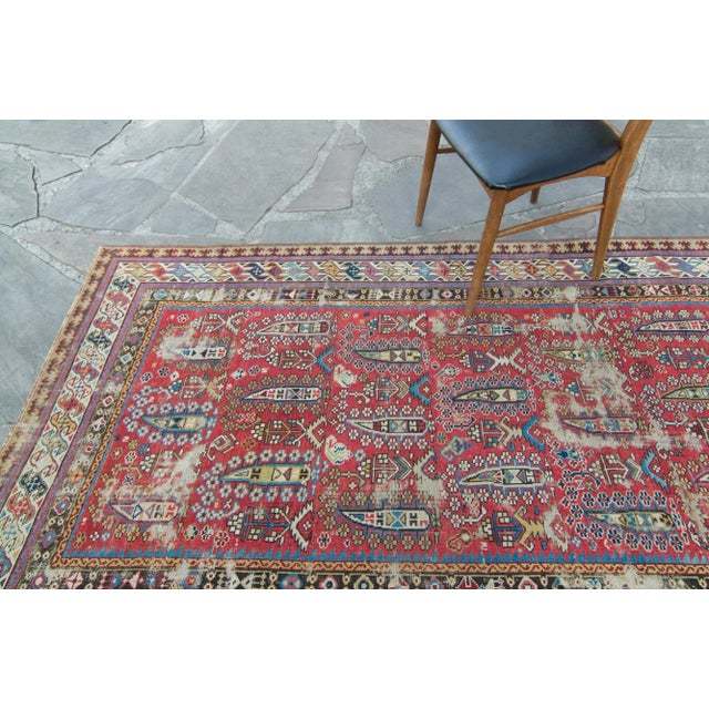 A rich field of geometric shapes takes center stage on this naturally distressed antique Shirvan runner. With a color...