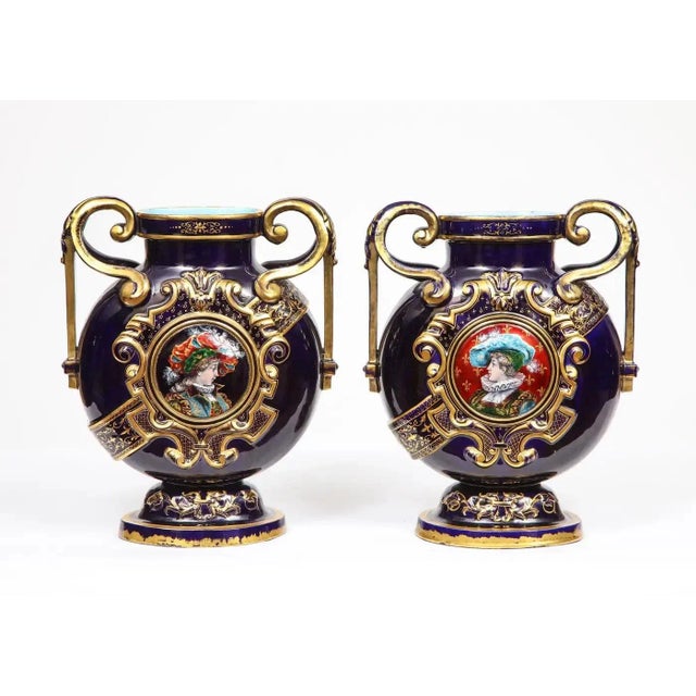 A rare pair of cobalt blue porcelain and Limoges enamel portrait vases. France, late 19th century. Elaborately gilded to a...