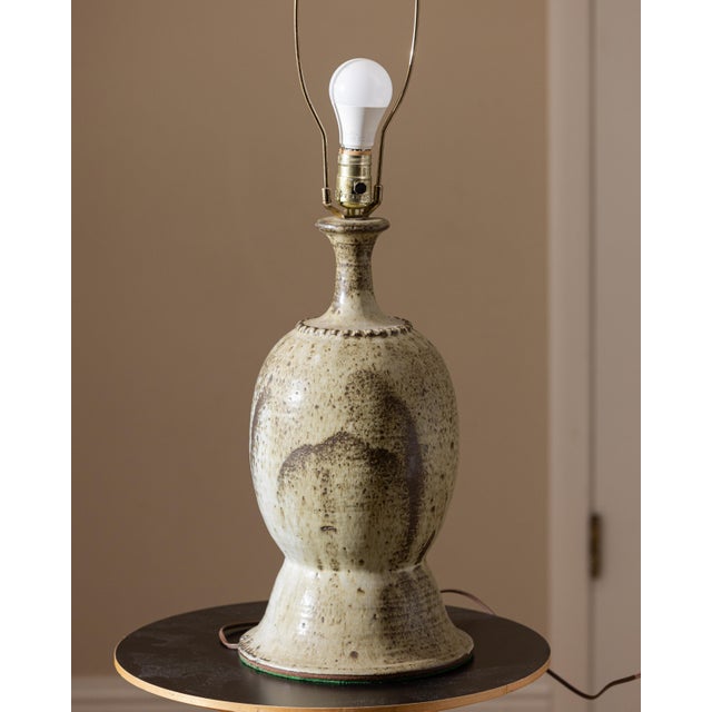 Signed and dated Petzold '73 studio pottery table lamp featuring a hand-thrown stoneware body with a richly textured cream...