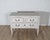 A charming French chest of drawers dating to circa 1920, beautifully painted in a light sand tone that complements its...