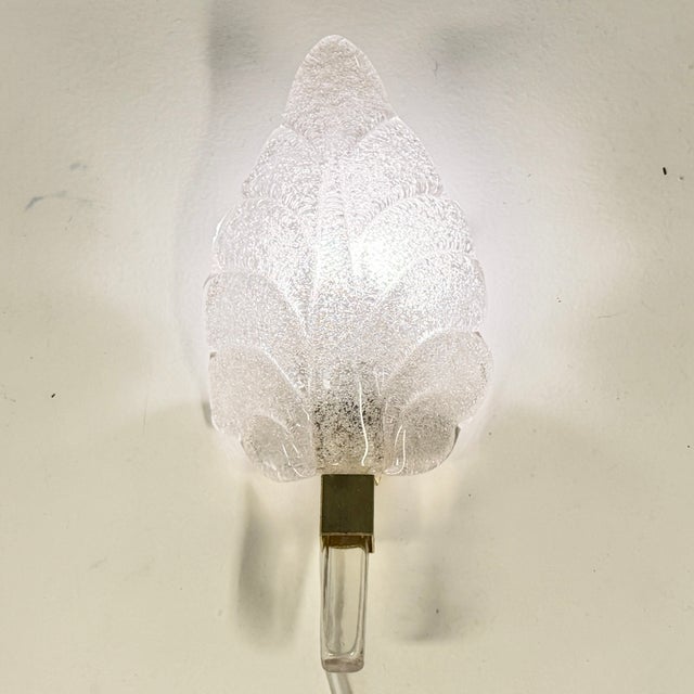 Elegant leaf-inspired wall sconce designed by Carl Fagerlund for Orrefors. The lamp features beautifully molded thick...
