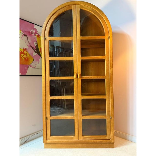 An exceptional arched display cabinet from Dyrlund, crafted from teak. The striking, architectural arched shape and two...
