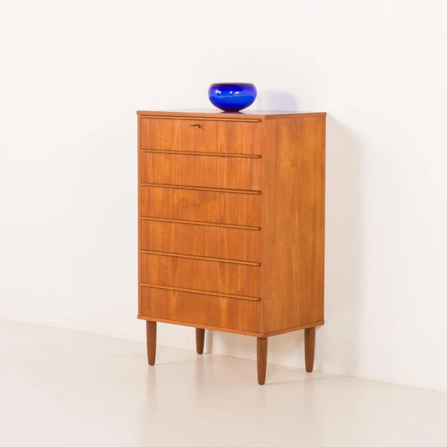 This vintage Danish teak chest of drawers from the 1960s is a refined example of mid-century modern craftsmanship. The...