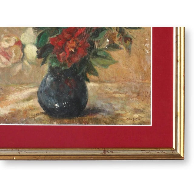 A beautifully composed vintage French still life featuring a vibrant bouquet of roses in a dark vase. The rich red and...
